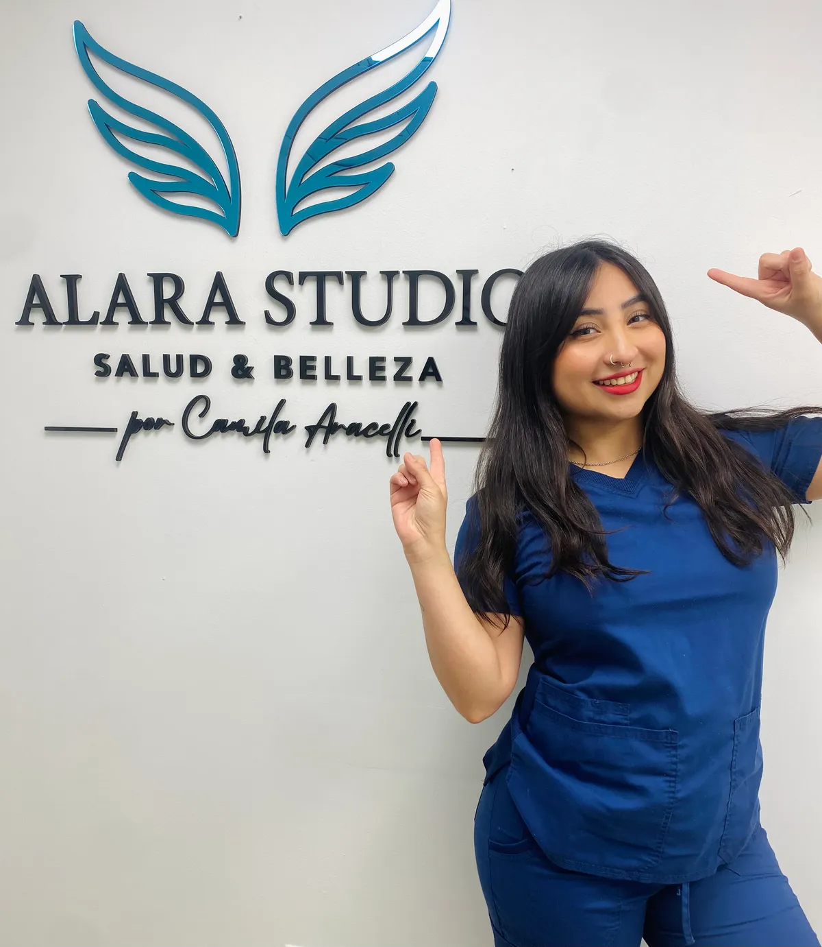 Camila Aracelli en Alara Studio, junto al letrero del estudio